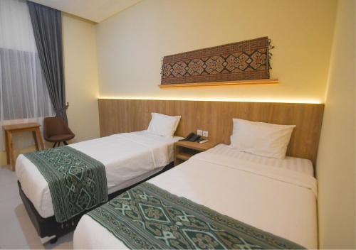 Pasola的酒店客房设有两张床和一张桌子。