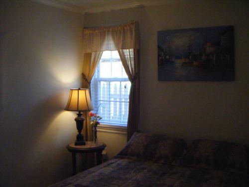 普罗温斯敦莫菲特之家宾馆的一间卧室配有一张床和一扇带灯的窗户