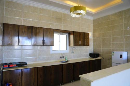 图赖夫Al Chaffa Chalets的厨房配有木制橱柜、水槽和窗户。