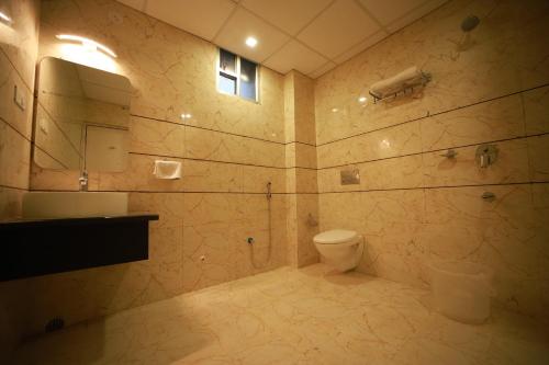 巴特那Click Hotel Capital House的一间带卫生间、水槽和镜子的浴室