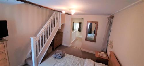 里士满16th Century 1 Bedroom Cottage (adjacent 10th Century Richmond Castle)的一间设有楼梯的房间,里面设有一张床