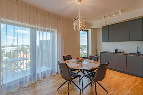 塔尔图Artisa Riia Str 22A Luxury apartment的厨房以及带桌椅的用餐室。