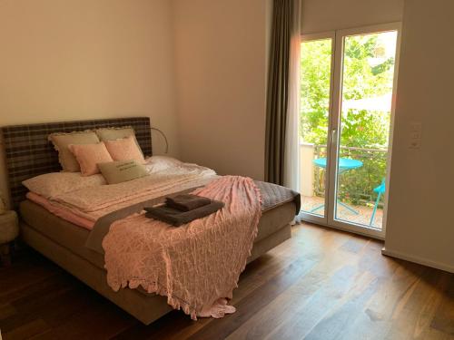 布里格Brig City Garden Apartment的一间卧室设有一张床和一个滑动玻璃门