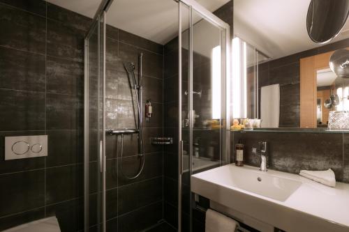 阿彭策尔狮子酒店的一间带玻璃淋浴和水槽的浴室