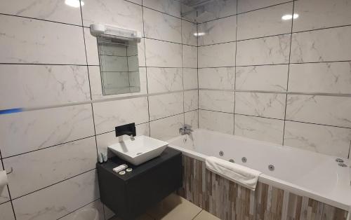 赫尔吉尔森酒店的浴室配有盥洗盆和浴缸。