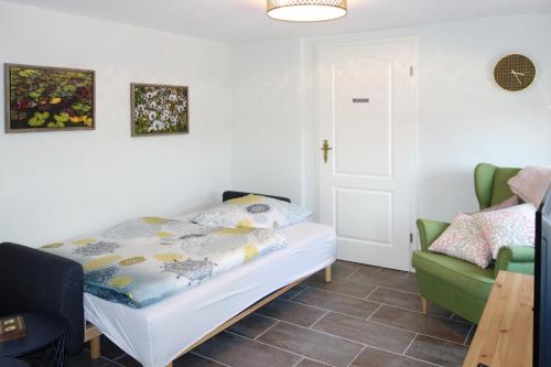 萨尔堡Das Kartenhaus的一间卧室配有一张床和一把绿色椅子