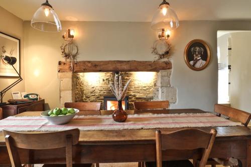 切尔滕纳姆Jasmine Cottage, Upper Slaughter, Cotswolds的一间带桌子和壁炉的用餐室
