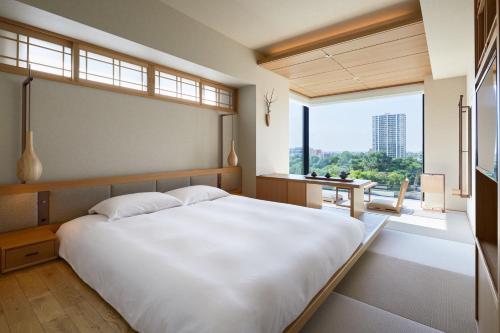 札幌ONSEN RYOKAN Yuen Sapporo的卧室设有一张白色大床和大窗户