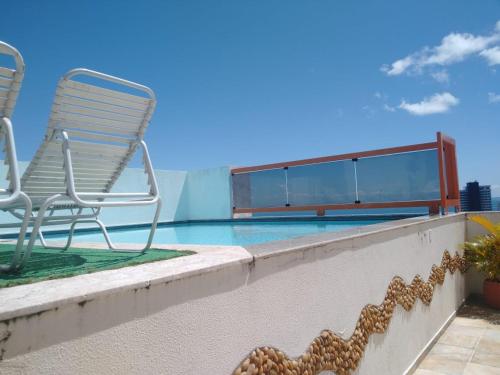 萨尔瓦多Barra Summer flat的一个带椅子的庭院和一个游泳池