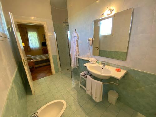 蒙塞利切卡洛卡瑞雷斯酒店的一间带水槽、卫生间和镜子的浴室