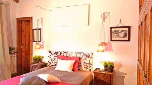 CastellciutatChalet "Rec dels Noguers"的卧室配有一张床,墙上挂着一张画框