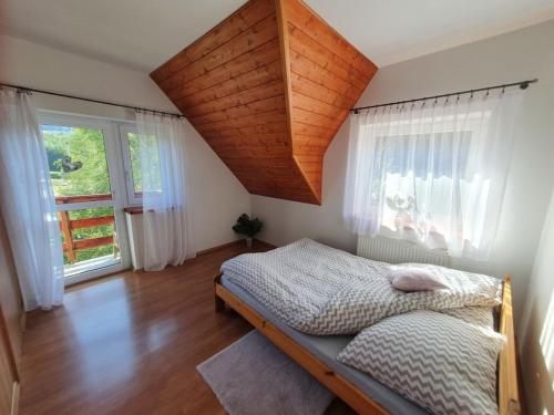 扎沃亚Zawoja 1895 sauna bania的一间卧室设有一张床和一个大窗户
