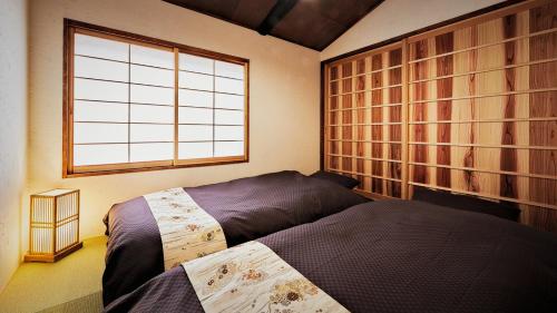 京都Kokonoe Machiya的一间卧室设有两张床和窗户。