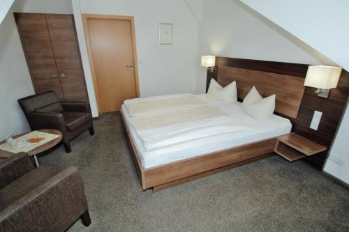 布尔韦勒温凯尼乐酒店的一间卧室配有一张床、一把椅子和一张桌子