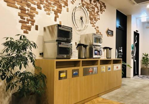 埼玉市大宫伊吉住宿酒店(EeGee Stay Omiya)的柜台上装有两个微波炉的商店