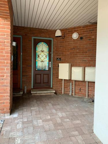 普里茅斯Mitre Court Holiday Home的砖墙,有门和彩色玻璃窗