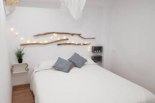 兰卡Amb encant i estil Mediterrani en zona tranquilla de Llançà i amb terrassa的一间卧室配有白色的床和灯。