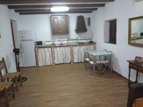 马尔莫莱霍La Casa del Abuelo Jose的客房设有带桌子和冰箱的厨房。