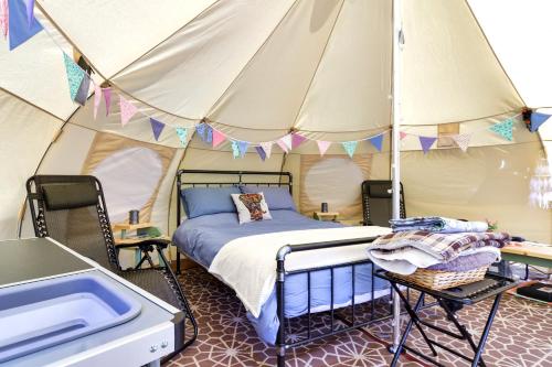 Little HautboisPitch Perfect Glamping Norfolk的帐篷内的一个床位房间