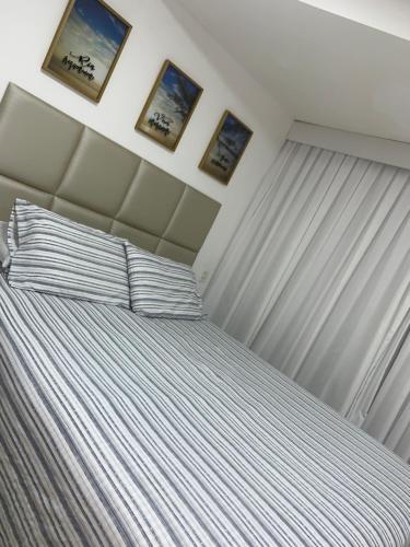 嘎林海斯港Marulhos Resort Flat Vista Mar的卧室配有一张墙上有两张照片的床。