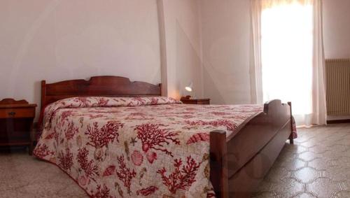 杜纳维德VILLA ROSA的一间卧室配有一张带红色棉被的床和窗户。