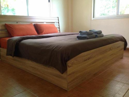 Ban Mae Kon简森之家度假屋的一间卧室配有一张带毛巾的大型木床