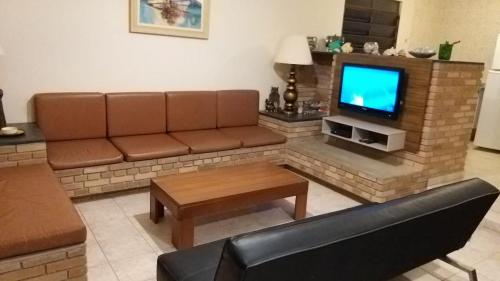 乌巴图巴Ubatuba Lagoinha Salga Mini Resort的带沙发和电视的客厅