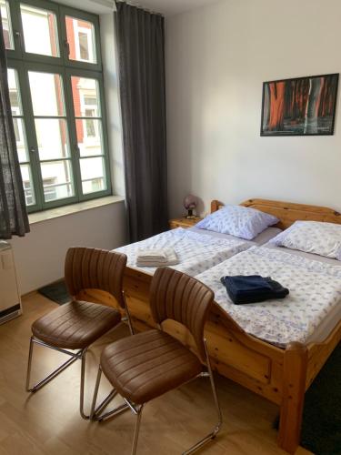 维斯马Altstadt Ferienwohnung的一间卧室配有木床和两把椅子