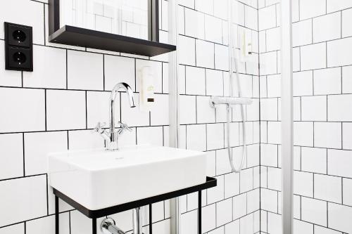 博登迈斯Winterfeld Guest House Bodenmais的浴室铺有白色瓷砖,配有白色水槽。