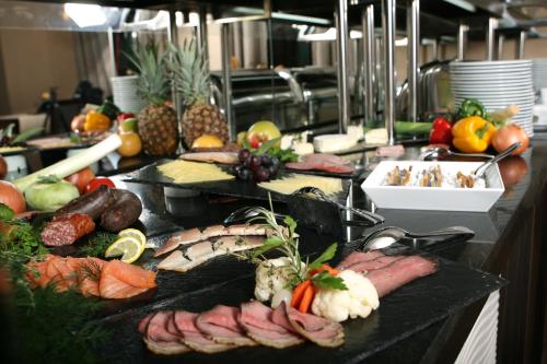 汉诺威Grand Palace Hotel Hannover的自助餐,包括餐桌上的肉类和蔬菜