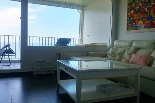 巴基奥Vistas 180º al mar/puesta de sol/Free Wifi-parking的带沙发和玻璃桌的客厅