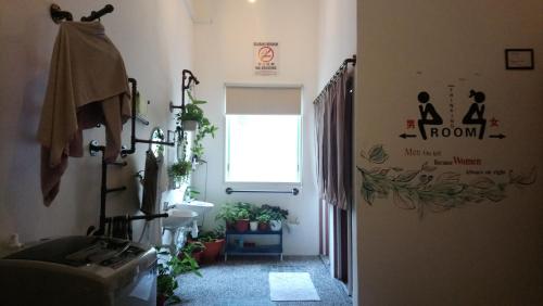 马六甲Stay With Me Capsules Hostel的一间带水槽、窗户和植物的浴室
