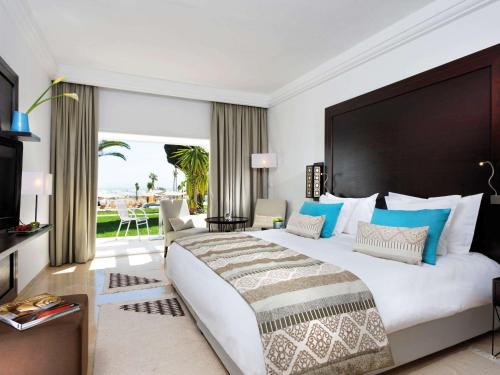 迦玛特突尼斯迦玛特慕温匹克酒店的一间卧室设有一张大床和一个大窗户