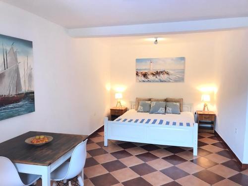 卢什蒂卡Villa Stella Rose的卧室配有白色的床和桌子