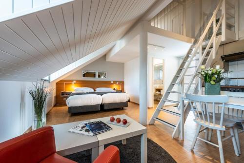 日内瓦欧派斯酒店的阁楼卧室设有一张床和一个楼梯