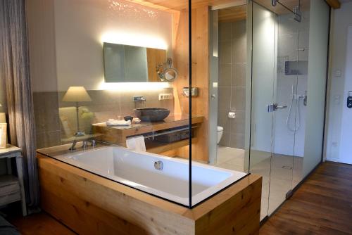 滨湖瓦京康体花园酒店的一间带大浴缸和玻璃淋浴的浴室