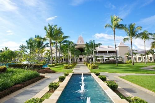 弗利康弗拉克Sugar Beach Mauritius的一个带游泳池和棕榈树的度假村