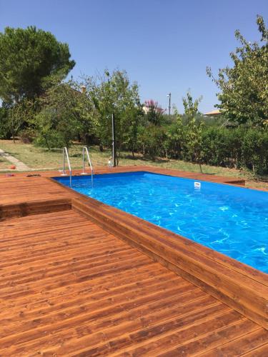 TreglioLa villa più bella con piscina的一个带木甲板和蓝色海水的游泳池