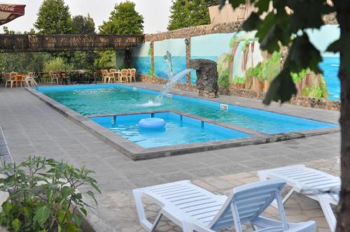 伊杰万Mayisyan Kamurj Hotel的一个带喷泉和两把草坪椅的游泳池