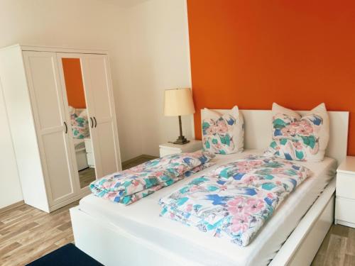 安娜贝格-布赫霍尔茨Ferienwohnung Klosterstrasse mit 2 Schlafzimmern的一间卧室配有白色的床和橙色的墙壁