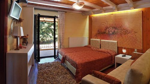 Koryshades哈尼帕家萨奇旅馆的一间卧室配有一张床、一台电视和一张沙发