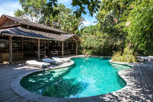 托兰克索UXUA卡萨酒店及Spa的一座房子旁带躺椅的游泳池