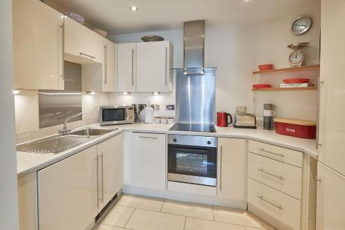 惠特比Host & Stay - The Eskape的厨房配有白色橱柜和炉灶烤箱。