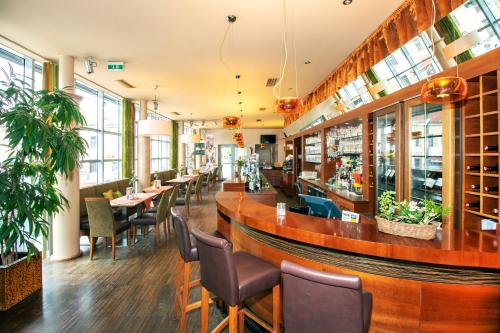 米尔茨楚施拉格温克勒酒店及餐厅的餐厅设有酒吧和桌椅