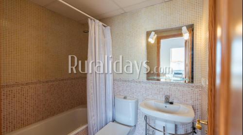 阿尔加罗沃First line beach apartment的一间带水槽、卫生间和镜子的浴室