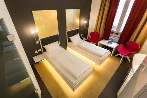 辛斯海姆辛斯海姆酒店的小房间设有两张床和两张红色椅子