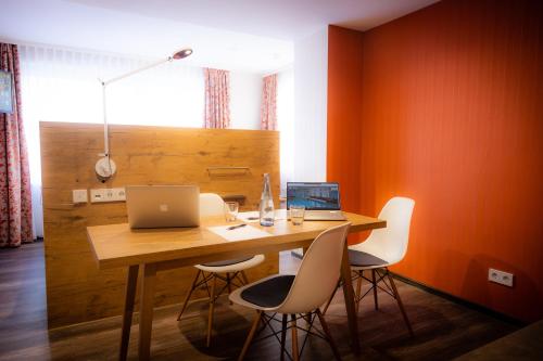 斯图加特阿森贝格酒店的用餐室配有带笔记本电脑和椅子的桌子
