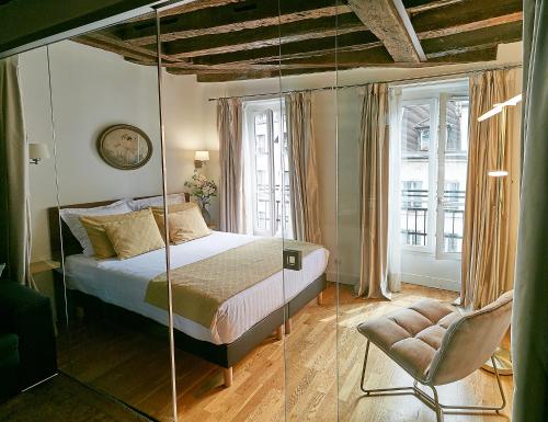 巴黎Apartments Du Louvre St Honoré的一间卧室配有一张床和一把椅子