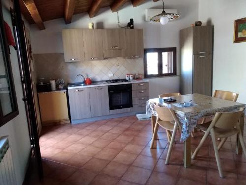 卡斯特布奥诺Casa Levante的一间带桌椅的厨房和一间带炉灶的厨房
