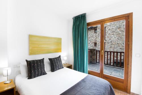 埃尔塔特德尔塔特露台公寓酒店的一间卧室设有一张床和一个大窗户